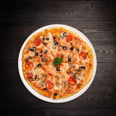 Peynirli, domatesli ve zeytinli dilimlenmiş pizza.