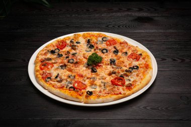 Peynirli, domatesli ve zeytinli dilimlenmiş pizza.