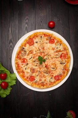 Peynirli, domatesli ve zeytinli dilimlenmiş pizza.
