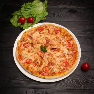 Peynirli, domatesli ve zeytinli dilimlenmiş pizza.