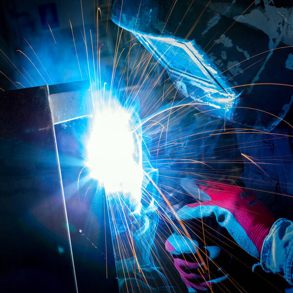 worker with plasma welding machine