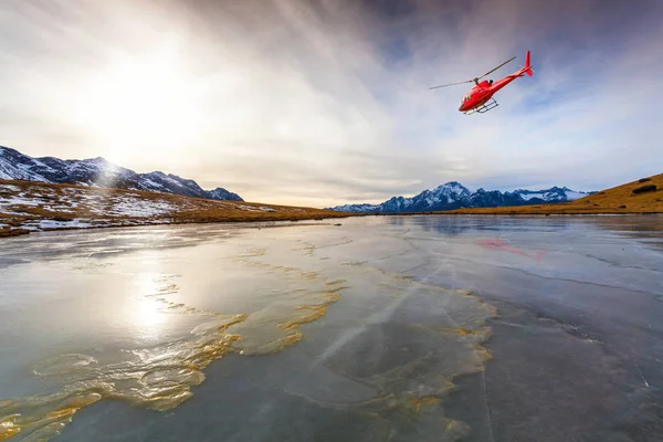 在冰湖上飞行的红色直升机 — 图库照片