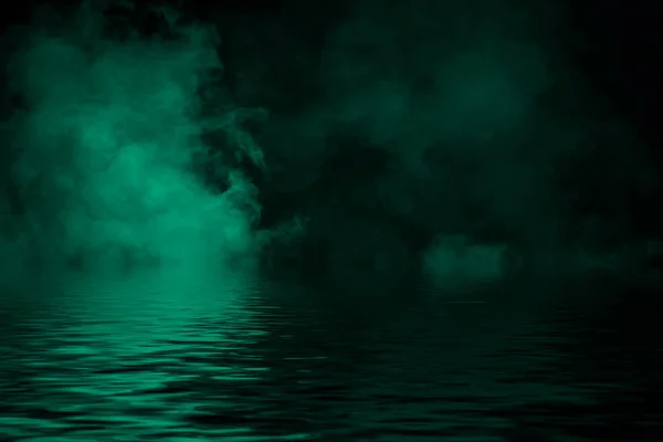 Прибрежный туман. Зеленый дым на берегу. Отражение воды  . — стоковое фото