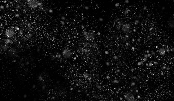 First falling snow bokeh texture on black background. Winter texture. — Stock Photo, Image
