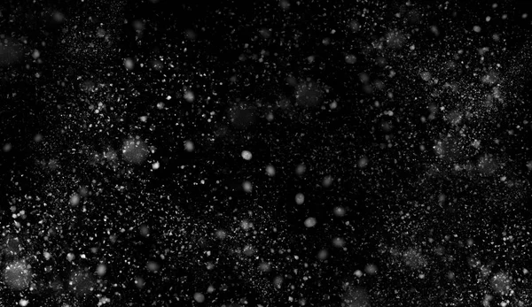 Primeira queda de textura bokeh neve no fundo preto. Textura de inverno . — Fotografia de Stock