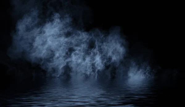 Modré zvlněné kouřové mlhy ze suchého ledu na dolním světle s odrazem ve vodě. — Stock fotografie