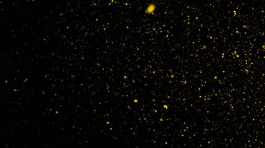 Sarı parçacıklar toz kalıntılarını siyah zemin üzerinde izole eder. Koyu dokuda hareket pudrası patlaması olur.