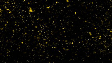 Sarı parçacıklar toz kalıntılarını siyah zemin üzerinde izole eder. Koyu dokuda hareket pudrası patlaması olur.