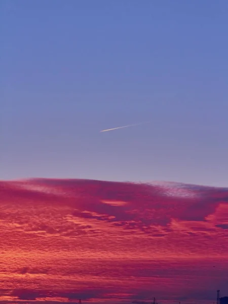 Pôr do sol com nuvens vermelhas e céu azul — Fotografia de Stock