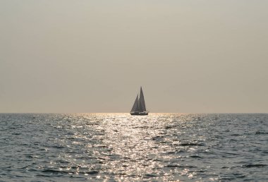 Sakin deniz ve güneşli gün parlayan suda yalnız Yelkenli teknede