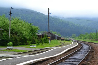 Karpat Dağları yakın Ukraynalı eyaletlerinden eski istasyonda eğri yolda ile boş demiryolu.