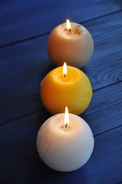 White Yellow Beige Spherical Paraffin Candles Burning Blue Wooden Table Stock Picture