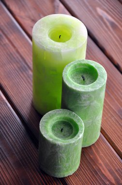 Üç fireless yeşil balmumu mum ahşap masa üzerinde farklı büyüklükte bir grup