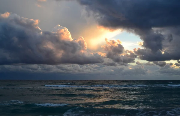 Break in the stormy cloudsover the sea waves