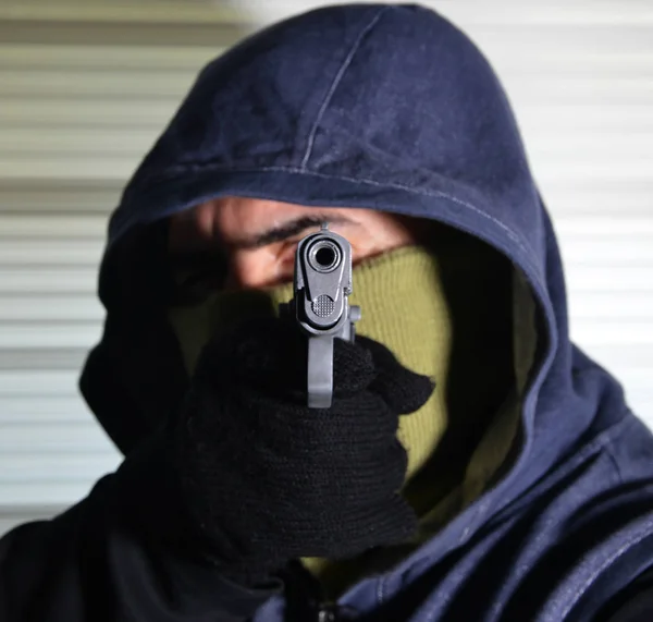 man in mask holding a pistol
