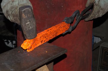 Kırmızı bir forge yoğun ısı sıcak, demirci ustaca el yapımı bir bıçağın üstüne kontur parlak metal inşaat.