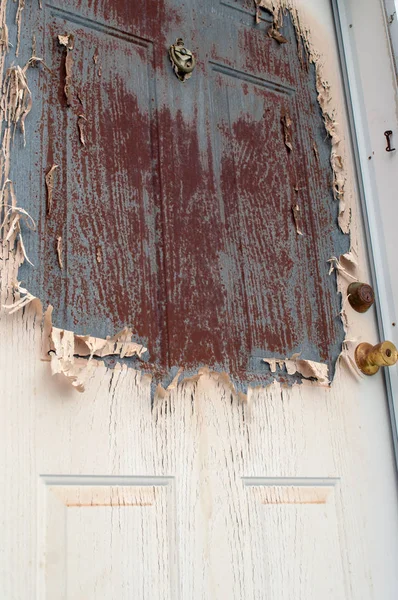 An exterior door that has been left neglected is now an eyesore in need of maintenance work from a handyman.