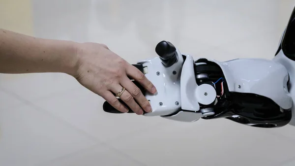 man welcomes the robot by shaking hands