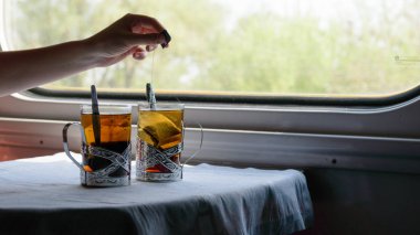 Glass with tea in train railway carriage clipart