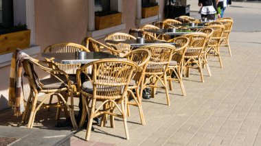 Sokakta hasır sandalye ile masasatır