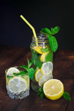 siyah bir arka plan üzerinde ahşap bir masa üzerinde nane ile limon suyu