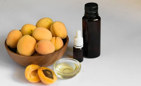 Alperce e óleo de semente de damasco sobre um fundo branco — Fotografia de Stock