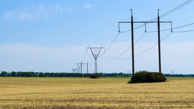 mavi gökyüzüne karşı bir alanda güç hatları