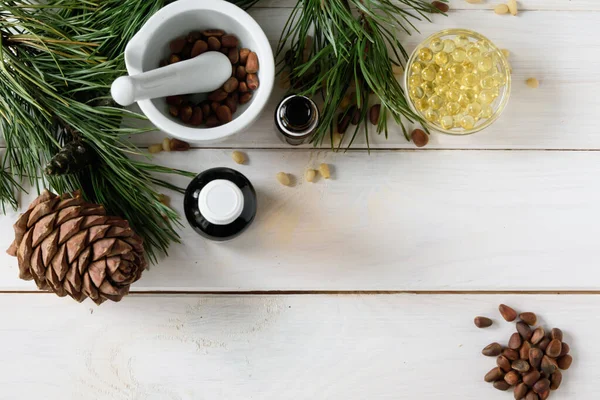 Óleo de cedro, ramos e cone de cedro em branco. Espaço para cópia. Beleza e conceito saudável.Energizando soros de sementes faciais . — Fotografia de Stock