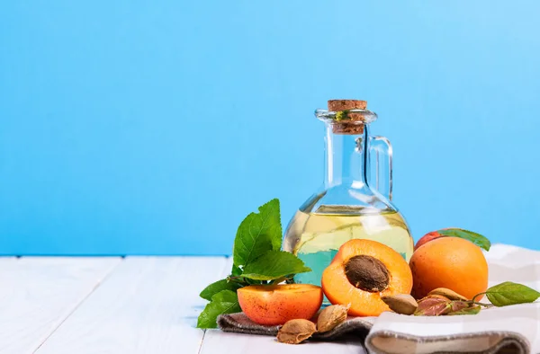 Bottle Apricot Oil Seeds White Wooden Table Blue Background — Stock Photo, Image