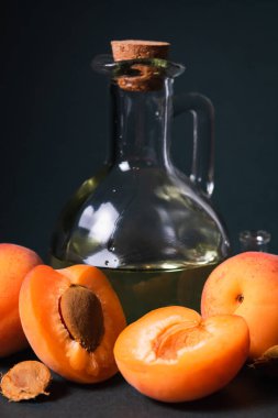 Masanın üzerinde kayısı çekirdeği yağı şişesi olan kompozisyon