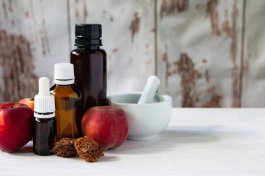 Beyaz ahşap zemin üzerinde, yağlı ve harçlı cam şişeli şeftaliler.