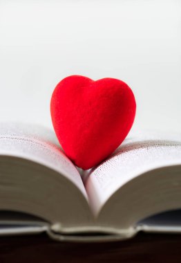 Aşk kavramı, kırmızı kalp beyaz arka planda bir kitabın sayfalarında