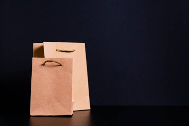 Alışveriş konsepti, siyah arka planda kağıt poşetler