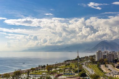 Antalya Cty Konyaalt sahiller, Beydaglar dağlar etek ve bulutlu bir mavi gökyüzü görünür