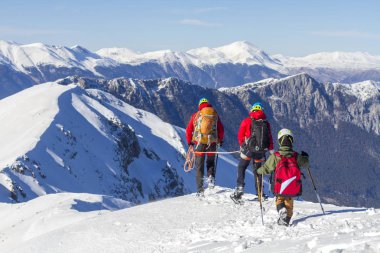 3 dağcı dağlarda kar üzerinde yürüyor