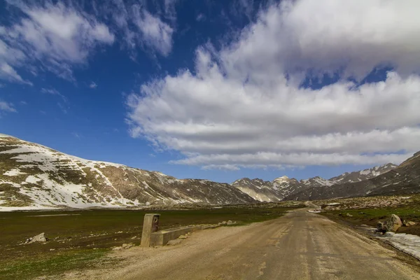 En molnig himmel, Highland vägar i de snöiga bergen — Stockfoto