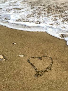 Deniz kıyısı tarafından çizilen dalgalar ve Kumlar çizilmiş kalp