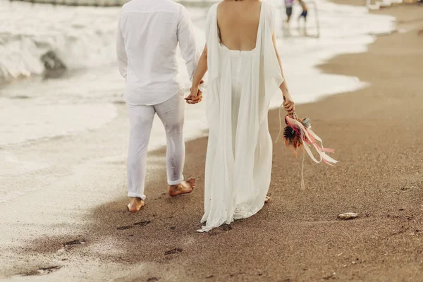 Bruid Bruidegom Wandelen Schokkerig Strand Bruid Heeft Bloemen Haar Hand — Stockfoto