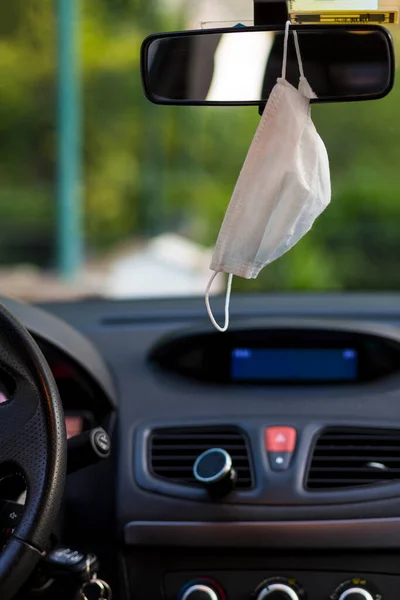 Yüz maskesi arabanın dikiz aynasında asılı.