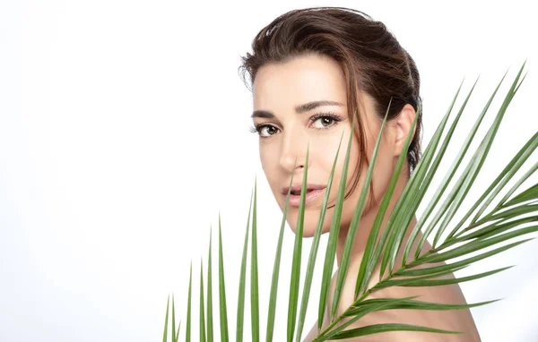 Schoonheid gezicht spa vrouw met groene tropische blad. Huid- en ontlasting — Stockfoto