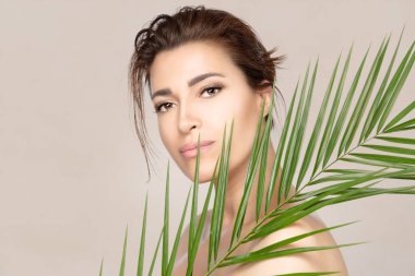 Yeşil tropikal yapraklı güzellik merkezi kadını. Spa, cilt bakımı ve...