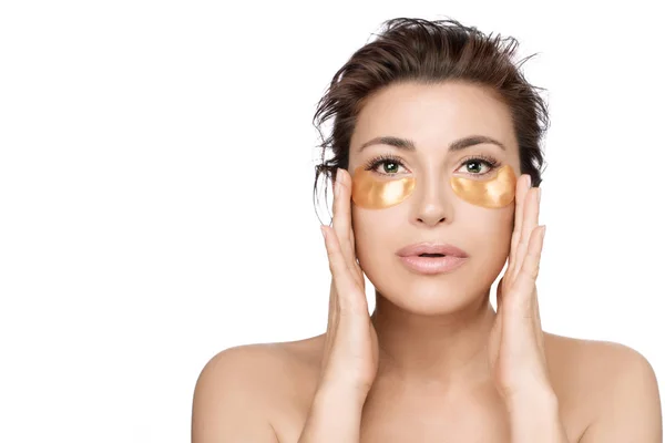 Mujer que usa parches para los ojos de colágeno para prevenir el envejecimiento de la piel. Oro h —  Fotos de Stock