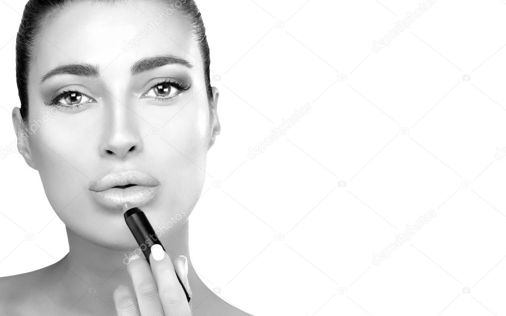 Monochrome beauty model applying lipstick to her lips isolated o
