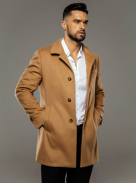 Красивый молодой человек в стильном костюме позирует
