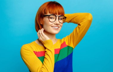 Kızıl saçlı ve gözlüklü güzel gülümseyen kadın modeli