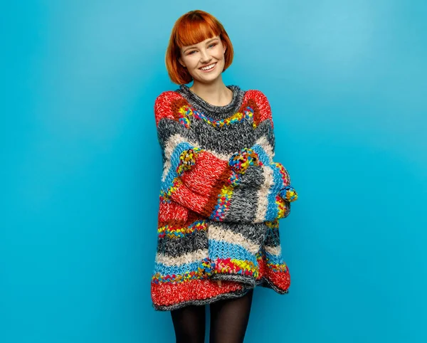 Colorful photo of young smiling female model wear oversize sweater isolated on blue background