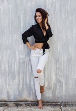 Güzel bir Afrikalı-Amerikalı kadın gülümsüyor ve yalınayak standları