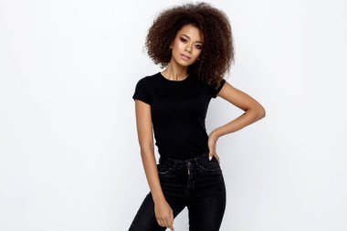Siyah elbise giyen ve üzerinde beyaz izole kamera bakarak afro bir saç modeli ile güzel bir Afrikalı-Amerikalı kadın