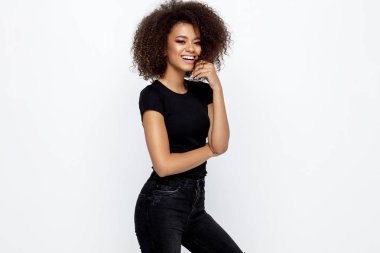 Siyah elbise giyen ve üzerinde beyaz izole kamera bakarak afro bir saç modeli ile güzel mutlu bir Afrikalı-Amerikalı kadın
