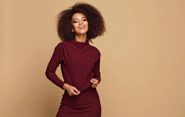 Beautiful african american model with copy space looking at camera and touching her sweater